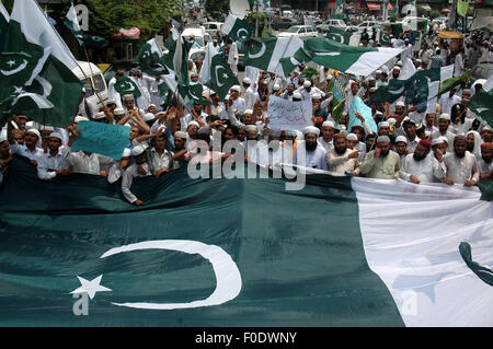 Lahore. 13th Aug, 2015. Pakistani people carry a national flag as they march on a street on the eve of the country's Independence Day celebrations in eastern Pakistan's Lahore on Aug. 13, 2015. Pakistan will celebrate its 68th anniversary on Aug. 14. Credit:  Sajjad/Xinhua/Alamy Live News Stock Photo