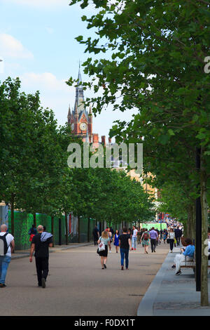 People walking along King's Boulevard with the St Pancras Clock Tower Stock Photo