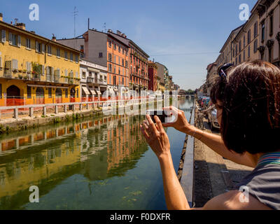 Tourist photographing canal side buildings in the Naviglio region of Milan, Italy Stock Photo