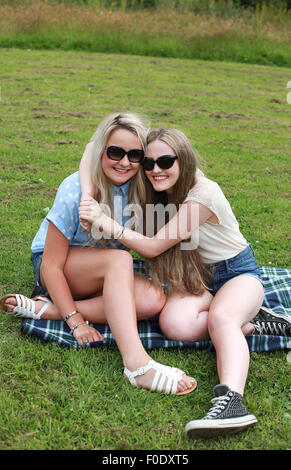 Two teenage girls outdoors with their arms around each other Stock Photo