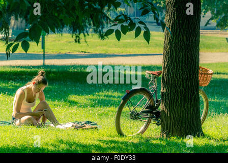 Girl listening to MP3 player in Montanelli Park, Milan Stock Photo