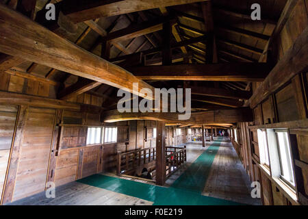 Japan, Kanazawa castle. Interior of the Sanjyukken storehouse. View along wooden interior with shooting windows and cross beams supporting the roof. Stock Photo