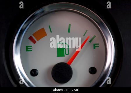 White fuel gauge with red needle showing full tank Stock Photo