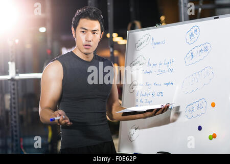 Coach making exercise plan in gym Stock Photo
