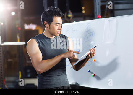 Coach making exercise plan in gym Stock Photo