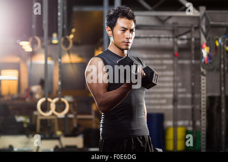 Young man lifting weights at gym Stock Photo