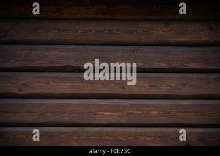 Dark Wood Logs Wall Photo Background. Log Home Wall Closeup. Stock Photo