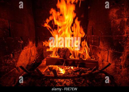 Burning Wood Logs Inside the Fireplace. Fireplace Heat. Stock Photo