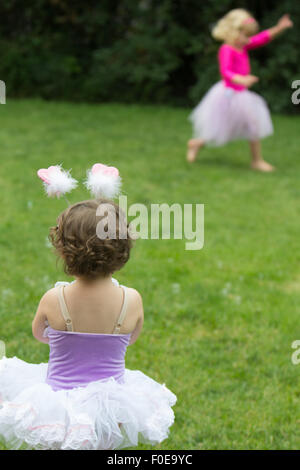 2 young girls playing outside in tutus Stock Photo
