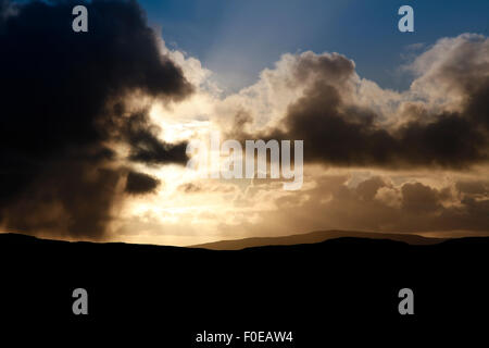 Sun breaking through dark clouds Stock Photo