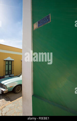 Old colonial center of Ciudad Bolivar with calle Bolivar on a green wall and a old American car in the background. Stock Photo