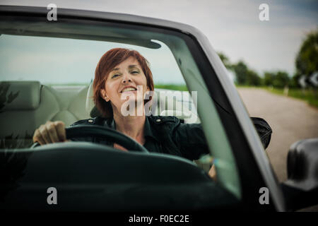 Woman enjoying driving her convertible car Stock Photo
