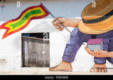 Man with hat and house and a Colombian flag in his hands, Massive vintage graffiti painted on a wall in Cartagena Stock Photo