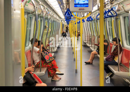 Kowloong, Hong Kong - August 13,2015: Commuters inside a train of the MTR of Hong Kong, the most popular mean of transportation Stock Photo