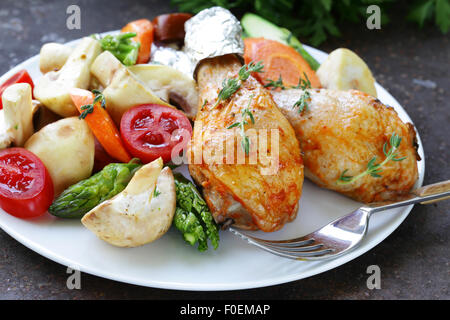 Fried chicken legs with herbs and spices, vegetables for garnish Stock Photo