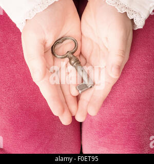 Little girl holding old vintage key in her hands Stock Photo