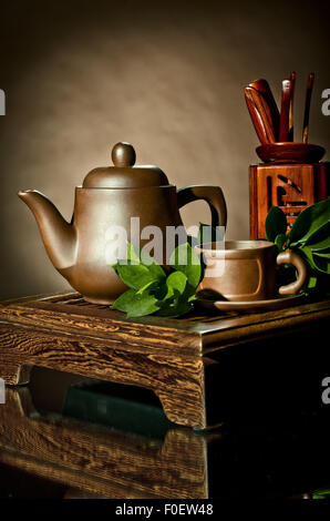 vertical photo, still life of the clay teapot and  cup on brown background Stock Photo
