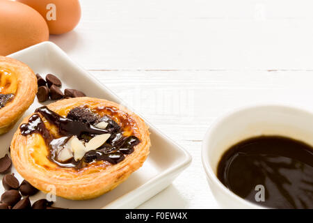 Traditional Portuguese egg tart to be eaten with coffee. Stock Photo