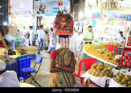 Mumbai, Maharashtra. 2nd Apr, 2014. 02 April 2014, Mumbai - India.A girl asks for donations in lieu of blessings from the Hindu Goddess from visitors at the Crawford Market.Crawford Market is the largest in Mumbai, and contains the last whiff of British Bombay.The Crawford Market houses a wholesale fruit, vegetable and poultry market. One end of the market is a pet store. Different varieties of dogs, cats, and birds can be found in this area. Most of the sellers inside the market sell imported items such as foods, cosmetics, household and gift items. It was the main wholesale market for f Stock Photo