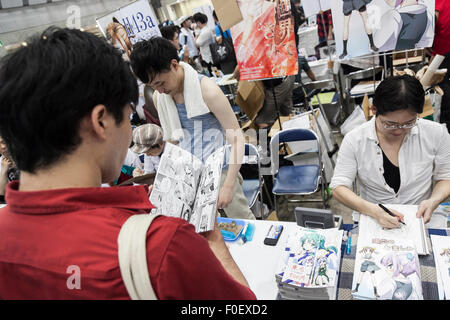 Tokyo, Japan. 14th August, 2015. A man reads a manga book during the ''Comic Market 88 Summer 2015'' exhibition at Tokyo Big Sight on August 14, 2015, Tokyo, Japan. Thousands of manga and anime fans attended the first day of the Comic Market 88 (Comiket) at Tokyo Big Sight. The Comic Market was established in 1975 to allow fans and artists to interact and focuses on manga, anime, gaming and cosplay. The exhibition is held from August 14th to 16th and Comiket organisers expect more than 500,000 visitors to attend. Credit:  Rodrigo Reyes Marin/AFLO/Alamy Live News Stock Photo