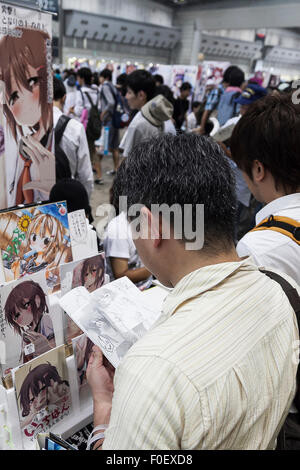 Tokyo, Japan. 14th August, 2015. A man reads a manga book during the ''Comic Market 88 Summer 2015'' exhibition at Tokyo Big Sight on August 14, 2015, Tokyo, Japan. Thousands of manga and anime fans attended the first day of the Comic Market 88 (Comiket) at Tokyo Big Sight. The Comic Market was established in 1975 to allow fans and artists to interact and focuses on manga, anime, gaming and cosplay. The exhibition is held from August 14th to 16th and Comiket organisers expect more than 500,000 visitors to attend. Credit:  Rodrigo Reyes Marin/AFLO/Alamy Live News Stock Photo