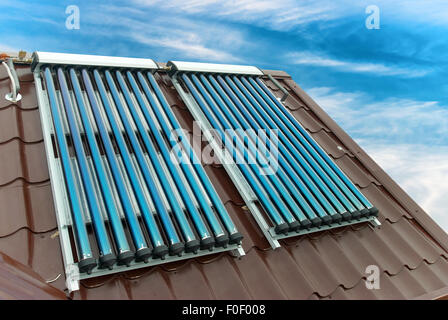 Vacuum solar water heating system on the house roof. Stock Photo