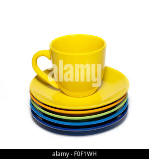 Yellow teacup and stack of saucers isolated on white. Stock Photo
