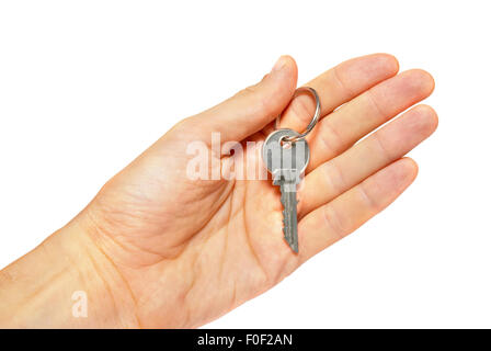 Silver key in a hand isolated on white. Stock Photo
