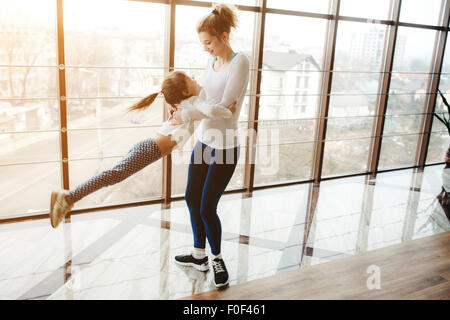 Mother twist her daughter in the gym Stock Photo