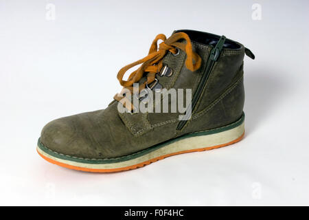 One child's freshly removed brown unisex boot, typically still laced, on a white cyclorama Stock Photo