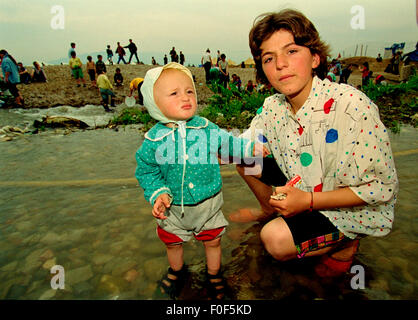 Kosovan refugees at camp Strankovic Macedonia 1999 , a baby stands in the stream that passes through the camp were people washed clothes Stock Photo