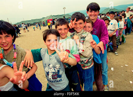 Kosovan refugees at camp Strankovic Macedonia 1999 , kids happy and playing whilst stood in food queues Stock Photo