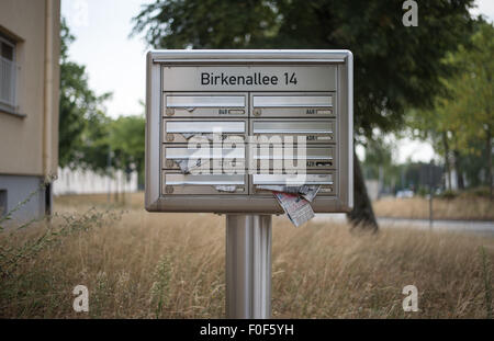 Bamberg, Germany. 14th Aug, 2015. Old mail hangs out of a post box in front of a housing block in the 'Warner Barracks' former US military base in Bamberg, Germany, 14 August 2015. The site is intended to become the second reception centre for asylum seekers from the Balkans. PHOTO: NICOLAS ARMER/DPA/Alamy Live News Stock Photo