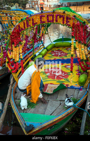 Decorated boat for hire with rower and rabbits on the ghats of Chitrakoot, (Chitrakut), Madhya Pradesh, India Stock Photo