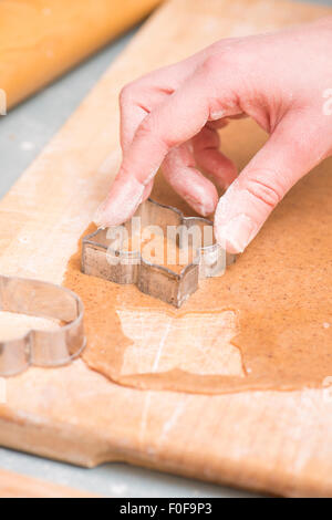 Hand of woman baking ginger bread cookies as christmas preparation. Stock Photo