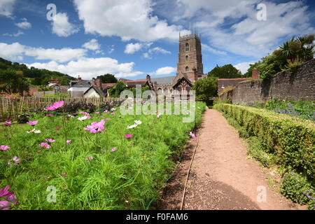 The idyllic English village of Dunster in Somerset, the flowers providing a wonderful foreground to the church. Stock Photo