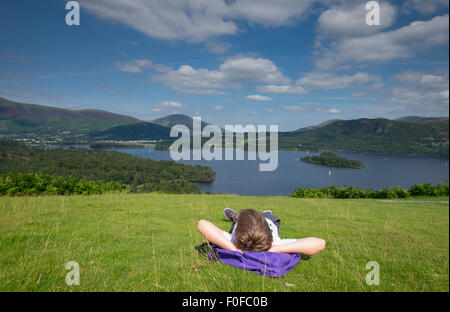 A boy stops to take in the view of Derwentwater in the Lake District from Catbells fell near Keswick, Cumbria, UK Stock Photo
