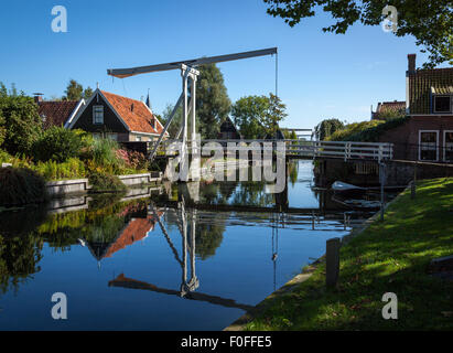 Traditional rural setting of a small village in Holland, Netherlands. Suspension foot bridge crossing over teh river. Stock Photo