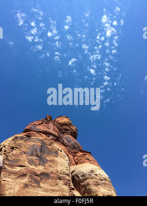 A rock formation in The Needles district with sparse white clouds against a blue sky Stock Photo
