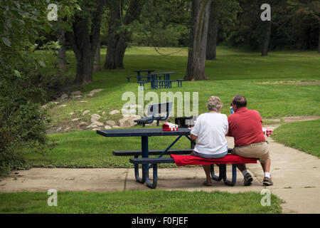 Senior couple having a picnic lunch on a hazy afternoon at Ferguson Township Park in Okemos, Michigan, USA Stock Photo