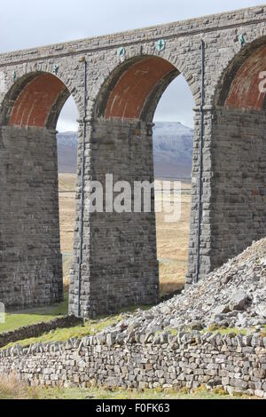 Snow capped mountain seen through arches of viaduct Stock Photo