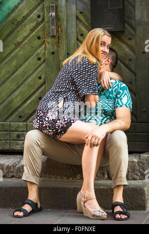 Happy young couple sitting on the steps of the old house. Stock Photo