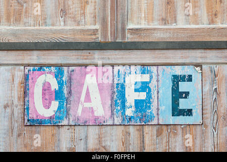 Old weathered cafe sign on distressed rustic wood wall Stock Photo