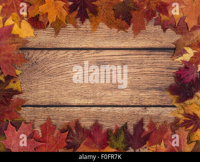 Autumn leaves border against wooden background Stock Photo