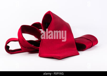 Single crumpled red silk tie belonging to a modern business man on a white background Stock Photo