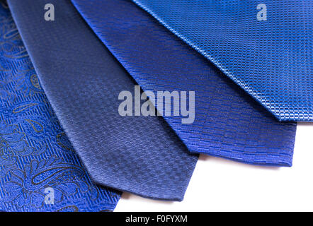 Four blue silk ties in a display row belonging to a modern business man on a white background Stock Photo