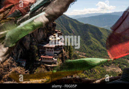 Taktsang or Tiger's Nest Monastery with colourful prayer flags in the foreground Paro Valley Bhutan Stock Photo