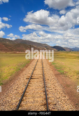 Rail tracks of the Andean Explorer Train through the Peruvian Highlands and Andes mountains on a beautiful sunny day Stock Photo