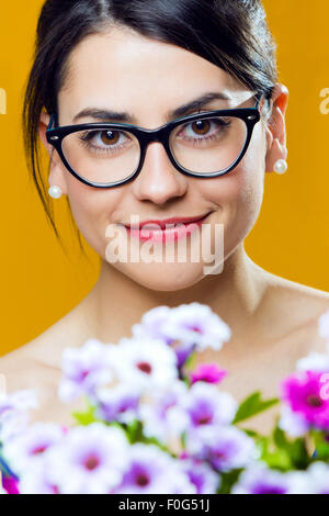 Studio portrait of happy young girl with flowers Stock Photo