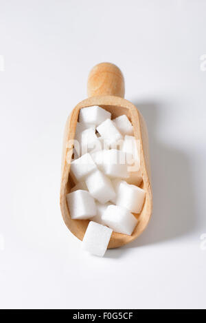 White sugar cubes in wooden scoop Stock Photo